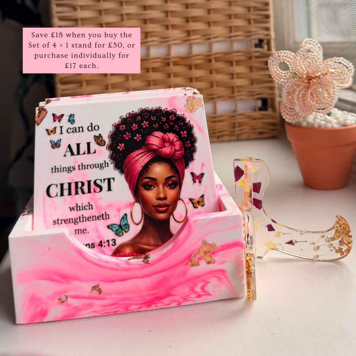 Pink Bible verse coaster set of four displayed on its presentation case, with  stand beside it.