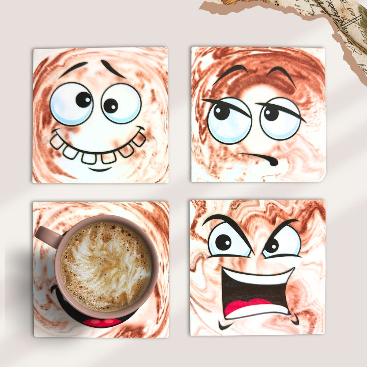 Set of four Mood Swings handmade eco-ceramic coasters featuring different funny facial expressions on brown and cream marble-effect backgrounds.