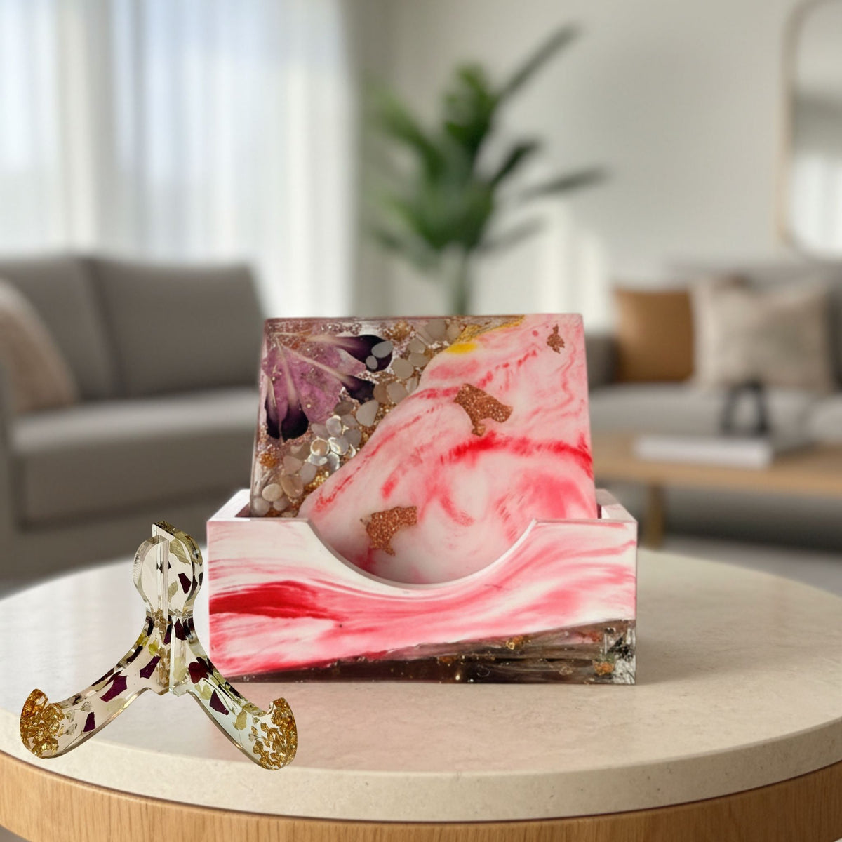 Pink marble floral coaster set displayed on its presentation case, with a stand beside it