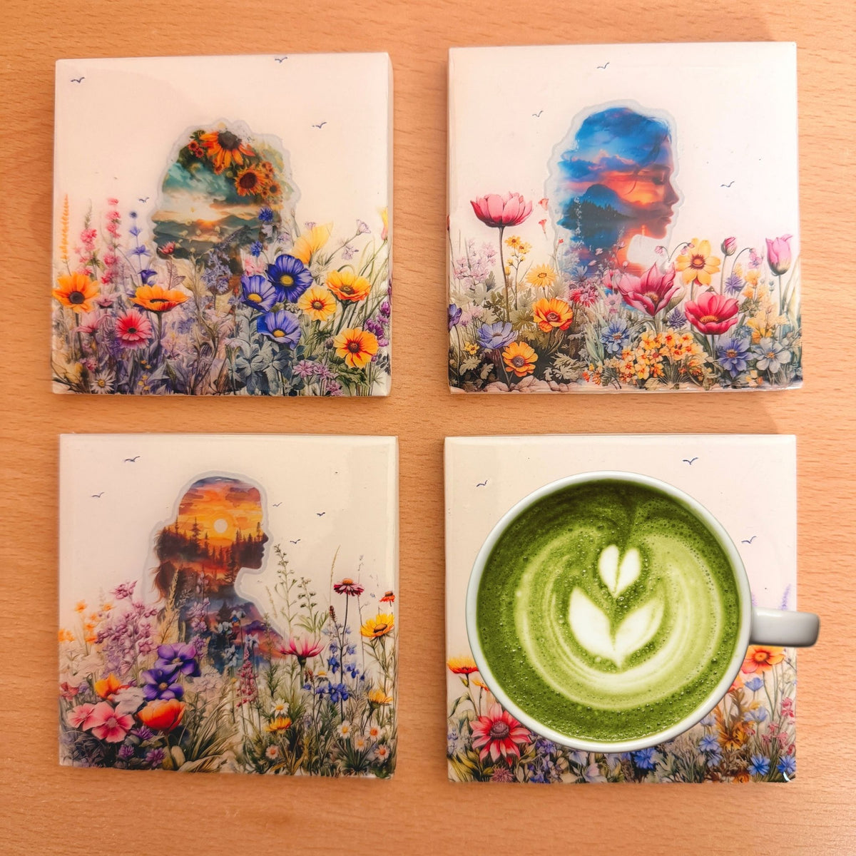 Four Nature Within eco-ceramic coasters featuring women's silhouettes filled with colourful landscapes, sunsets and flowers.